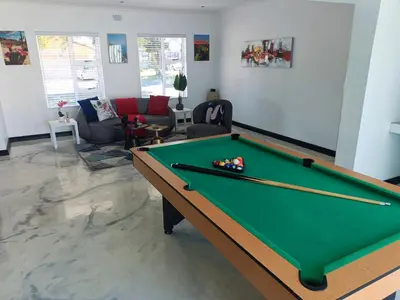 a living room with a pool table in a room at Frangipani House in Goodwood