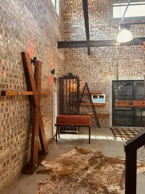 a room with a bench and a brick wall at Tether and Tease, The Fortress in Cape Town