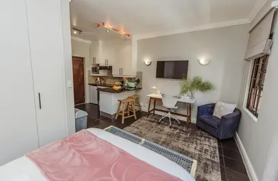 a living room with a bed and a kitchen at Studio in Central Stellenbosch in Stellenbosch