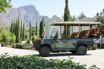 a green jeep with chairs and a golf cart at Oakvale Estate in Franschhoek