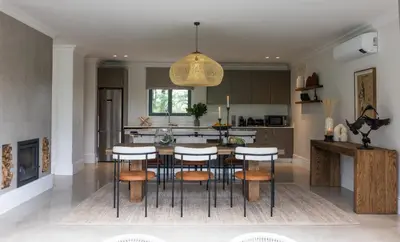 a kitchen with a table and some stools at Oakvale Estate in Franschhoek