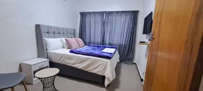 a small bedroom with a bed and a window at Twinex Accommodation Parow in De Grendel