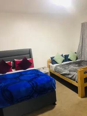 a bedroom with two beds with colorful pillows at Twinex Accommodation Bellville in Stikland