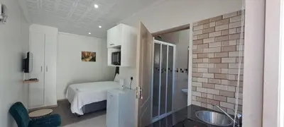 a bathroom with a bed and a sink in a room at Twinex Accommodation Bellville in Stikland