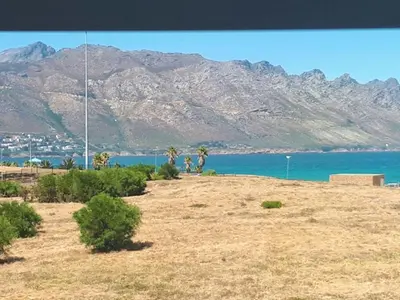 a view of the ocean and mountains from a hill at Golfbeach Luxury self catering apartment in Cape Town