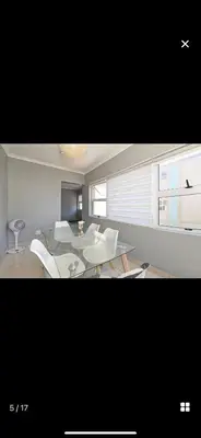 a living room with a table and white chairs at YA Eagle Wings Self Catering Shared Single Room Lodge A in Cape Town