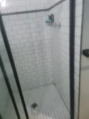 a bathroom with a shower with white tiles at Mikasa Cukasa Geust House in Gordonʼs Bay