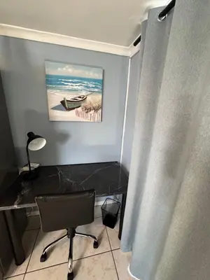 a room with a desk and a chair and a painting at Pemba Guest Cape Town in Cape Town