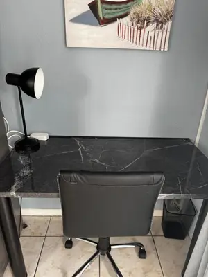 a black desk with a chair and a lamp at Pemba Guest Cape Town in Cape Town