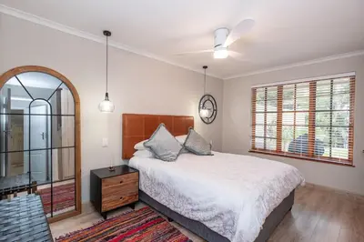 a bedroom with a bed and a ceiling fan at Serenity at Cape Bay in Helderberg