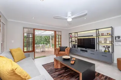 a living room with a couch and a tv at Serenity at Cape Bay in Helderberg