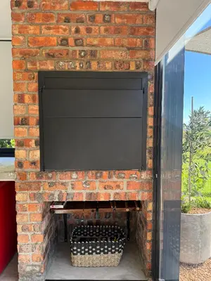 a brick fireplace with a television on top of it at EersteBosch Cottages in Stellenbosch