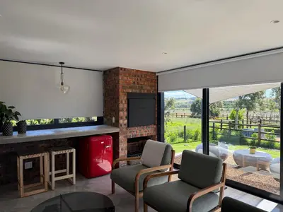 a living room with a fireplace and a tv at EersteBosch Cottages in Stellenbosch