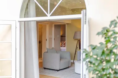 a living room with a chair and a window at The Helderview Luxury Suites in Somerset West