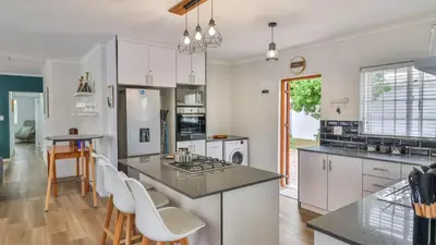 a kitchen with white cabinets and a counter top at Casa Mia in Hermanus