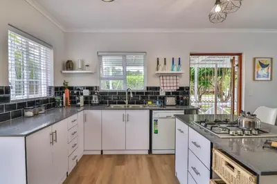 a kitchen with white cabinets and a stove top oven at Casa Mia in Hermanus