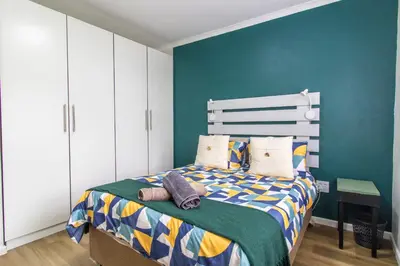 a bedroom with a bed and a green wall at Casa Mia in Hermanus