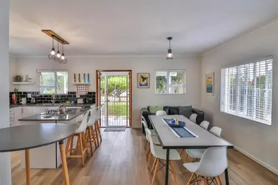 a kitchen and living room with a table and chairs at Casa Mia in Hermanus