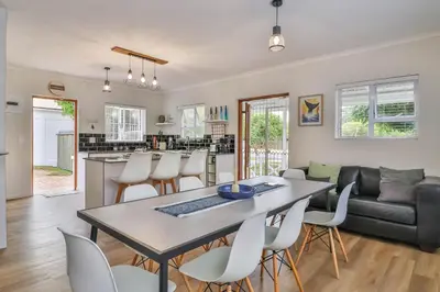 a kitchen and living room with a table and chairs at Casa Mia in Hermanus