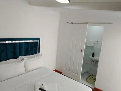 a bedroom with a bed and a bathroom with a mirror at Duminy Guest Lodge in Bellville