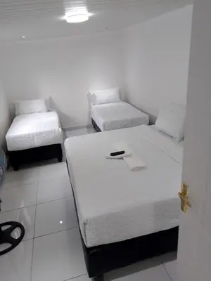a room with two beds and a remote control on top at Duminy Guest Lodge in Bellville