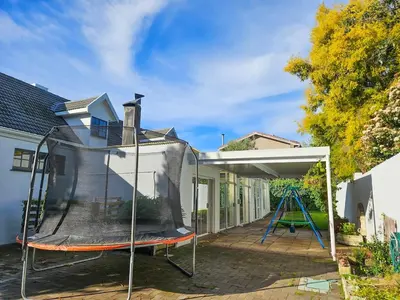 a batting cage in a backyard with a swing at Indoor Pool Paradise in Stellies in Stellenbosch