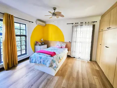 a bedroom with a bed and a yellow wall at Indoor Pool Paradise in Stellies in Stellenbosch