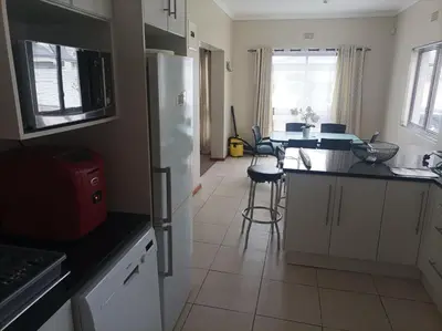 a kitchen with a white refrigerator and a table at Vues Du Mont in Hermanus