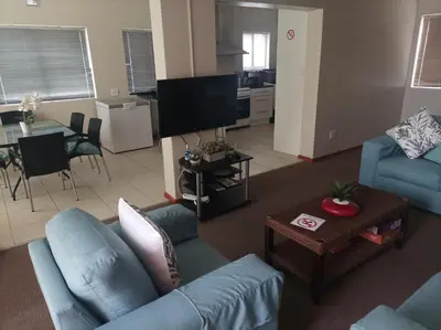 a living room with a blue couch and a table at Vues Du Mont in Hermanus