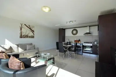 a living room with a couch and a table at Quayside 1 Bedroom Apartment in Century City in Cape Town