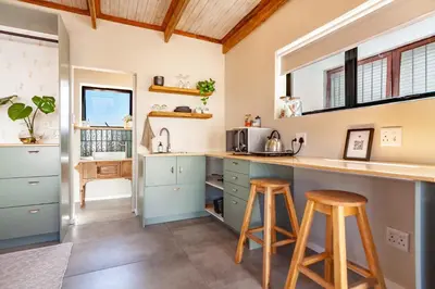 a kitchen with blue cabinets and wooden stools at Lily's Pad in Oakdale