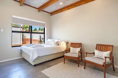 a bedroom with a large bed and two chairs at Lily's Pad in Oakdale