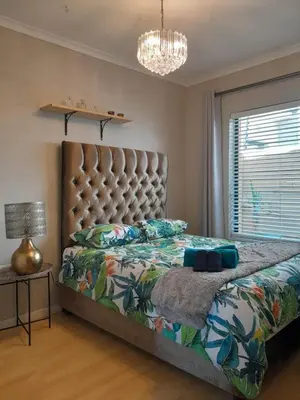 a bedroom with a large bed and a chandelier at Yannas Guesthouse in Cape Town