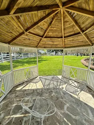 a patio with two chairs under a wooden roof at Blossom Cottage, Elgin Grabouw in Grabouw