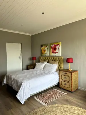 a bedroom with a large white bed and a table with lamps at Blossom Cottage, Elgin Grabouw in Grabouw