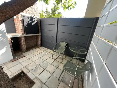 a small patio with two chairs and a fireplace at Te Môi in Paarl