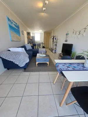 a living room with a couch and a table at Spacious Beachside Apartment in Cape Town