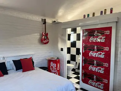 a bedroom with a coca cola sign next to a bed at The Cola Cabana in Cape Town
