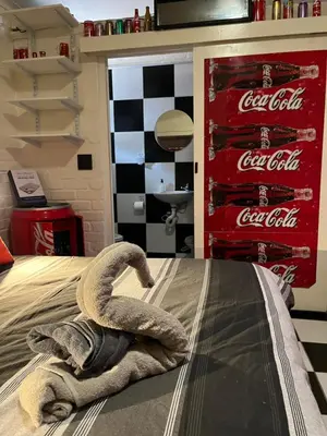 a room with a coca cola sign on the bed at The Cola Cabana in Cape Town