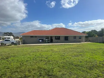 a house with a grass yard in front of it at Laid-Back Tortoise in Fisherhaven
