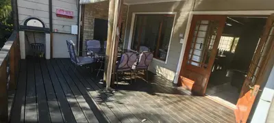 a porch with chairs and a table on a house at Franschoek - Holiday House on the River in Hou Moed