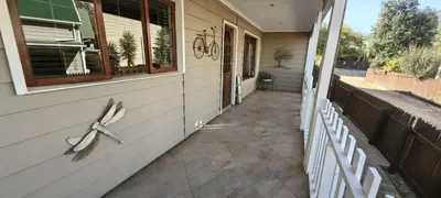 a porch of a house with a window and a pair of scissors at Franschoek - Holiday House on the River in Hou Moed