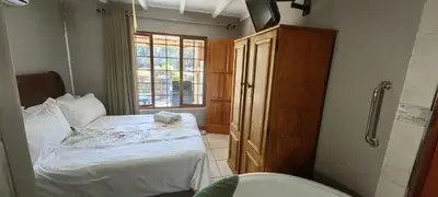 a small bedroom with a bed and a window at Franschoek - Holiday House on the River in Hou Moed