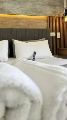 a bedroom with two beds with white sheets and pillows at 2 bed Luxury apartment living in Cape Town