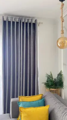 a couch with colorful pillows in front of a curtain at 2 bed Luxury apartment living in Cape Town