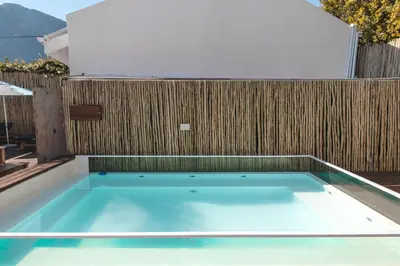 a swimming pool in front of a wooden fence at theLAB Franschhoek in Franschhoek