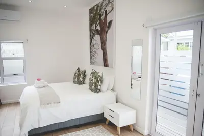 a white bedroom with a bed and a window at theLAB Franschhoek in Franschhoek
