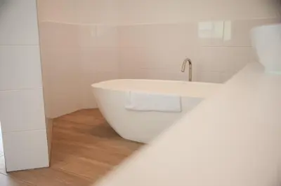 a white bath tub in a bathroom with a sink at theLAB Franschhoek in Franschhoek