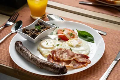 a plate of breakfast food with sausage and eggs at AnnaNella Boutique Hotel in Durbanville