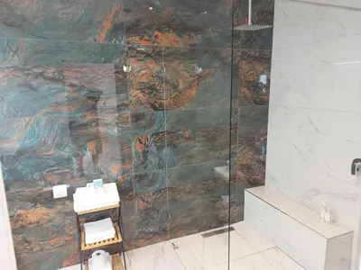 a bathroom with a shower with a painting on the wall at AnnaNella Boutique Hotel in Durbanville